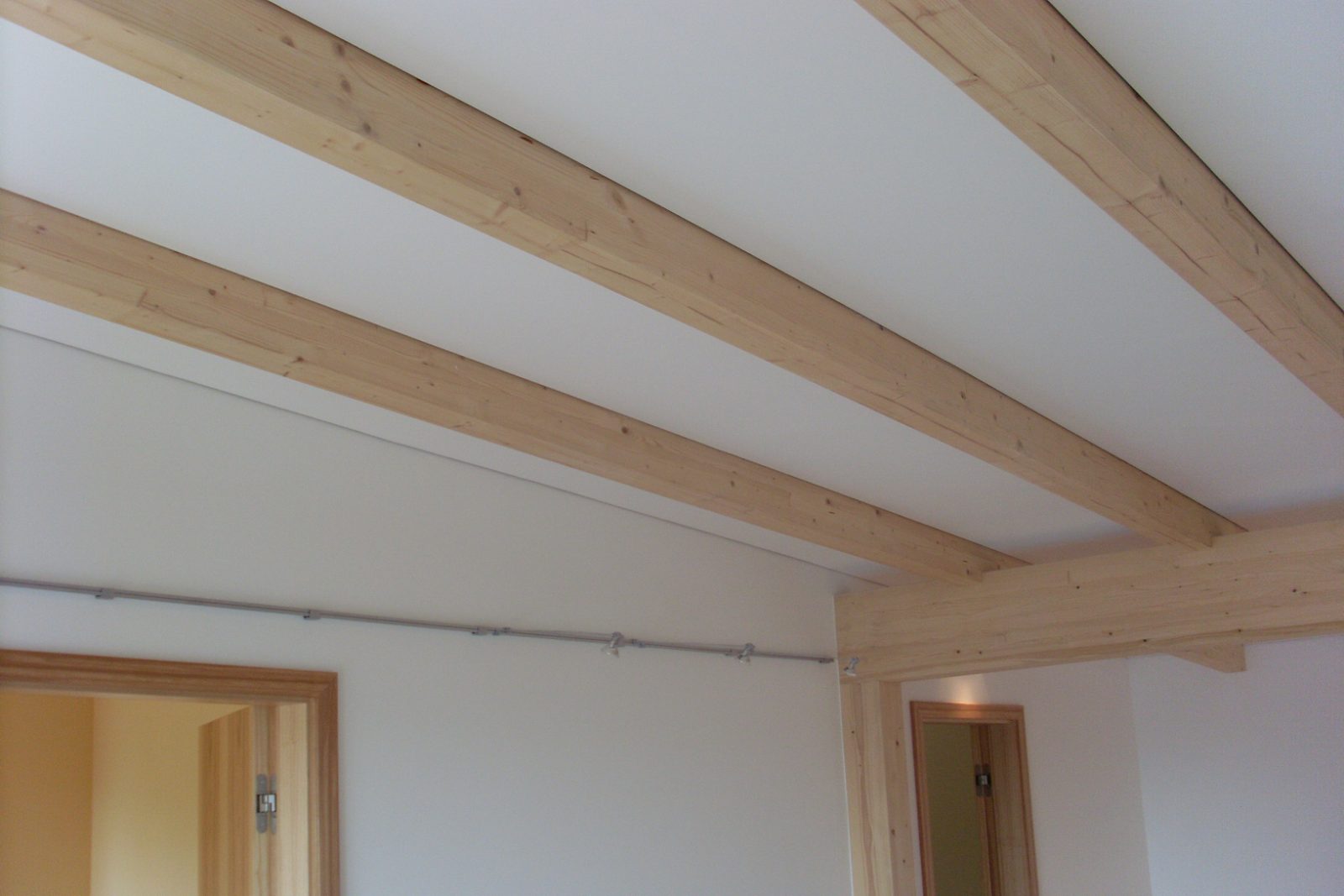 Fertige Decke zwischen sichtbaren Holzbalken mit umlaufender Schattenfuge